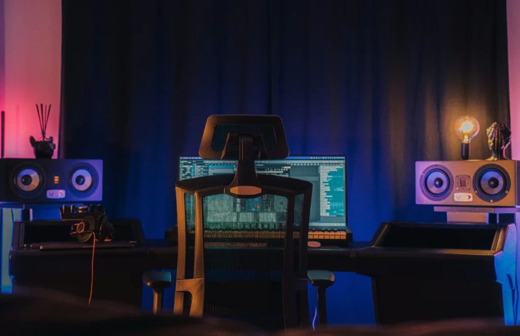 Studio room with a desk, chair, monitors, and a computer screen.